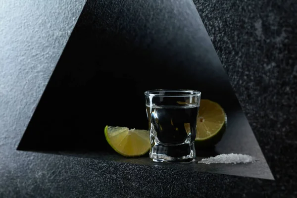 Mexican tequila with lime and sea salt, black background.