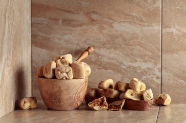 Mutfak seramik masasında ahşap bir tabakta kurutulmuş incir. Boşluğu kopyala.