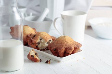 Mutfak masasında sütlü kekler. Beyaz ahşap bir masada ev yapımı üzümlü kek.. 