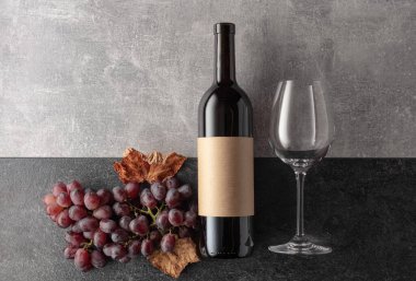 Arka planda üzümlü kırmızı şarap. Boş bir şişede. Üst görünüm.