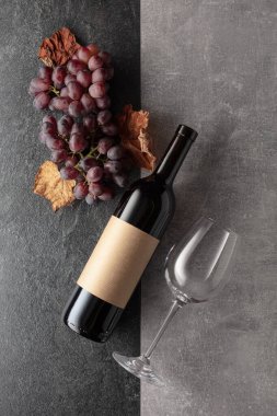 Arka planda üzümlü kırmızı şarap. Boş bir şişede. Üst görünüm.
