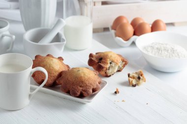 Mutfak masasında sütlü kekler. Beyaz ahşap bir masada ev yapımı üzümlü kek.. 
