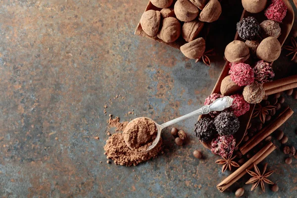 巧克力松露和勺子加可可粉 有肉桂 茴香和咖啡豆的糖果放在陈酿生锈的桌子上 顶部视图 — 图库照片