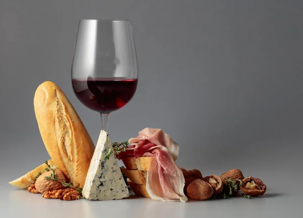 青いチーズ 赤ワイン バゲット クルミ タイムとProsciutto 伝統的な地中海の軽食と赤ワイン — ストック写真