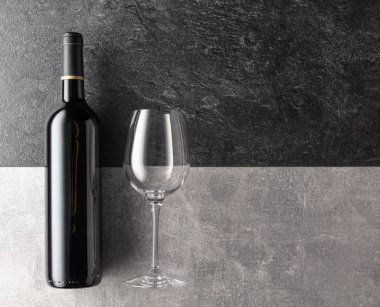 Taş zeminde bir şişe kırmızı şarap. Üst görünüm.