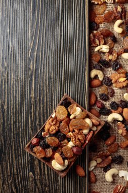 Kurutulmuş meyve ve fındık. Tahta bir masada fındık ve kuru üzüm karışımı. Kopyalama alanı olan üst görünüm.