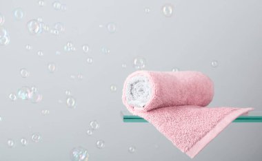 Cam bir rafta havlu. Kabarcıklı arka plan. Banyo ve hijyen teması. Boşluğu kopyala.