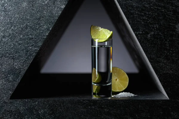 Mexican tequila with lime and sea salt, black background.