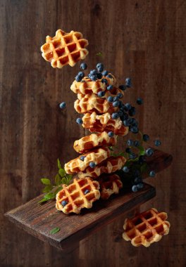 Eski ahşap bir arka planda taze yaban mersinli waffle..