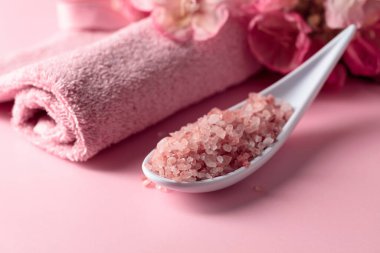 Pembe Himalaya tuzu, çiçeği ve havlusuyla spa kompozisyonu.