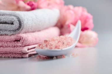 Pembe Himalaya tuzu, çiçeği ve havlusuyla spa kompozisyonu.