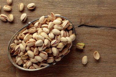 Eski ahşap bir masada tuzlu şam fıstığı. Üst görünüm.