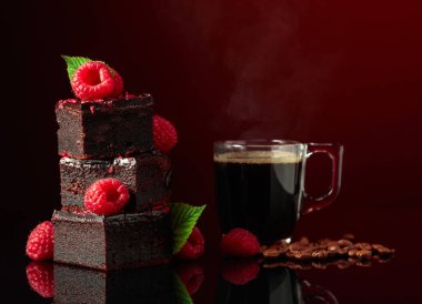 Chocolate cake with fresh raspberries and black coffee on a dark red background.