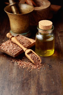 Keten tohumu ve keten tohumu yağı. Eski ahşap bir masanın üzerinde mutfak gereçleri ile keten tohumu yağı. Boşluğu kopyala. 