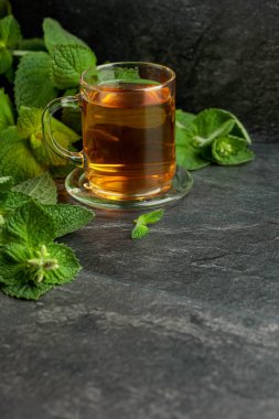 Mint tea in glass on a black table. Copy space.
