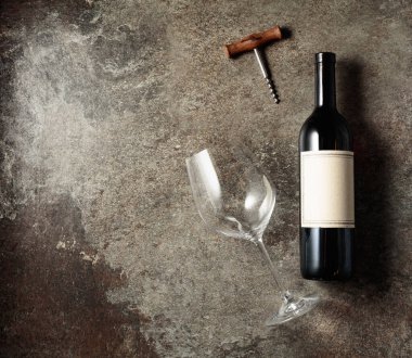 Eski kaba bir arka planda kırmızı şarap. Eski, boş etiketli bir şişe. Üst görünüm.