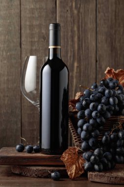 Red wine and blue grapes. Wine and grapes in a vintage setting on an old wooden table.