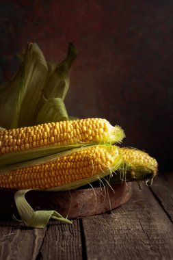 Fresh corn on cobs on a rustic wooden table.