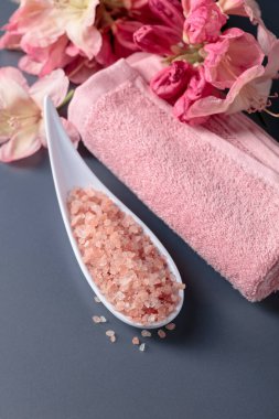 Pembe Himalaya tuzu, çiçeği ve havlusuyla spa kompozisyonu.