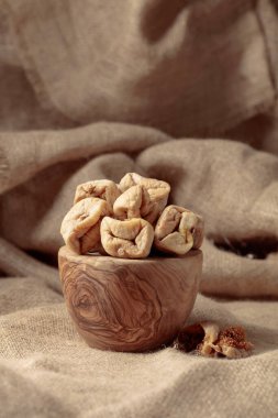 Çuval bezinde eski bir ahşap kapta kurutulmuş incir..