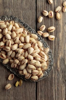 Eski ahşap bir masada tuzlu şam fıstığı. Üst görünüm.