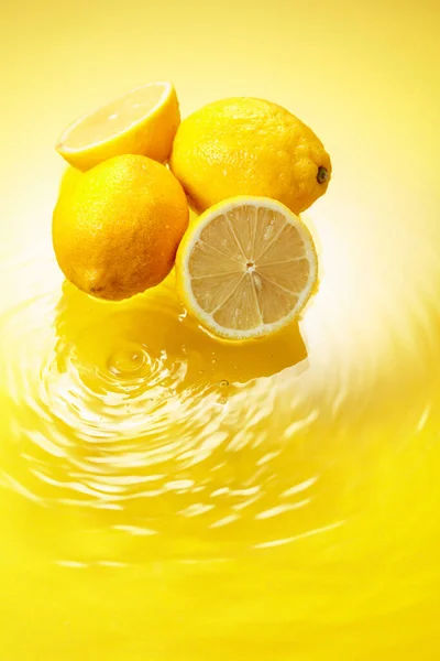Ripe Juicy Lemons Yellow Background Water Splashes Copy Space — Zdjęcie stockowe