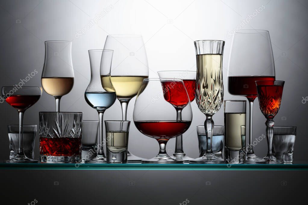 Various alcoholic drinks in the bar on glass shelves.