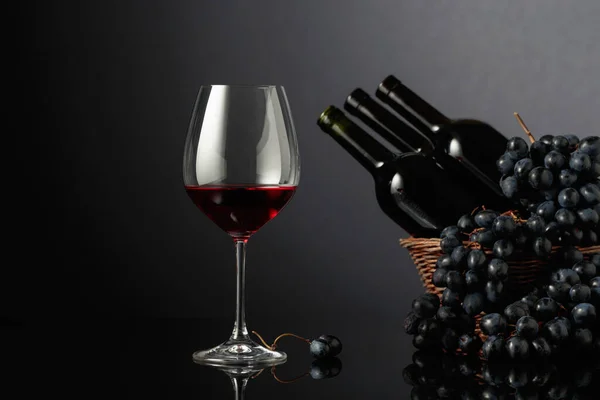 Red Wine Blue Grapes Black Reflective Background Focus Foreground — Stock Photo, Image
