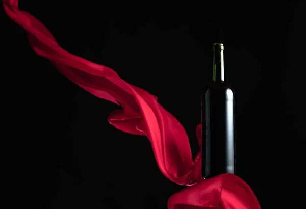 Eine Flasche Rotwein Auf Schwarzem Hintergrund Mit Flatterndem Rotem Tuch — Stockfoto