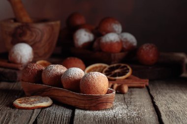 Balls of freshly baked homemade cottage cheese doughnuts sprinkled with sugar powder.