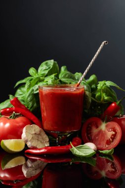 Baharatlı domates sosu ve malzemeler. Taze domates, kırmızı biber, sarımsak, fesleğen ve siyah arka planda limon. Boşluğu kopyala.