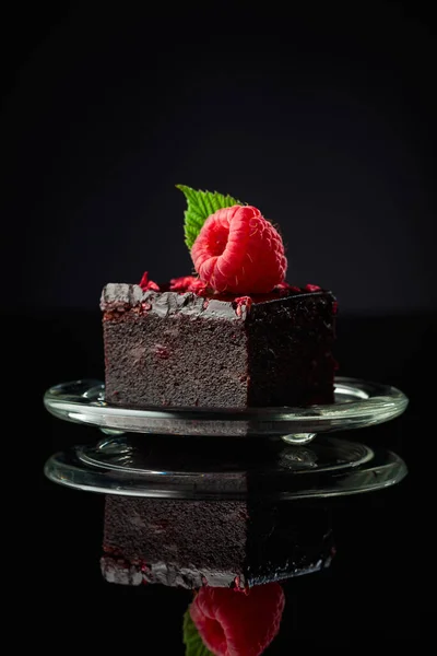 Schokoladenkuchen Mit Frischen Himbeeren Auf Schwarzem Reflektierendem Hintergrund — Stockfoto