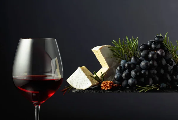 Rode Wijn Met Kaasbrie Walnoten Druiven Rozemarijn Een Zwarte Achtergrond — Stockfoto