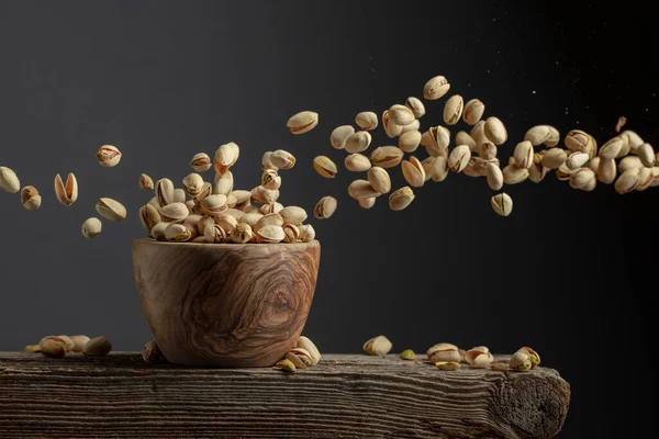 Flying Salted Pistachios Dried Nuts Wooden Bowl Copy Space — стоковое фото