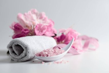 Pembe Himalaya tuzu, çiçeği ve havlusuyla spa kompozisyonu.