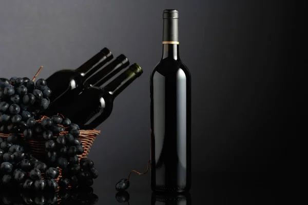 Red Wine Blue Grapes Black Reflective Background Focus Bottle — Φωτογραφία Αρχείου