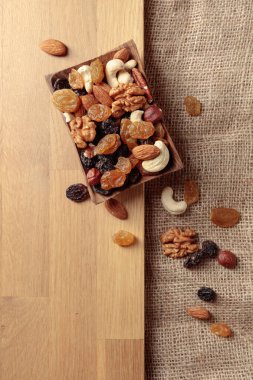 Kurutulmuş meyve ve fındık. Tahta bir masada fındık ve kuru üzüm karışımı. Kopyalama alanı olan üst görünüm.