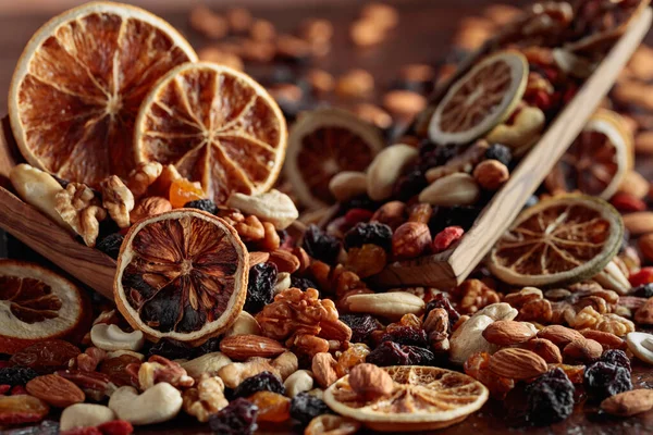 Dried fruits and nuts. Presented raisins, walnuts, almonds, goji berries, hazelnuts, cashews, and orange slices. Selective focus.