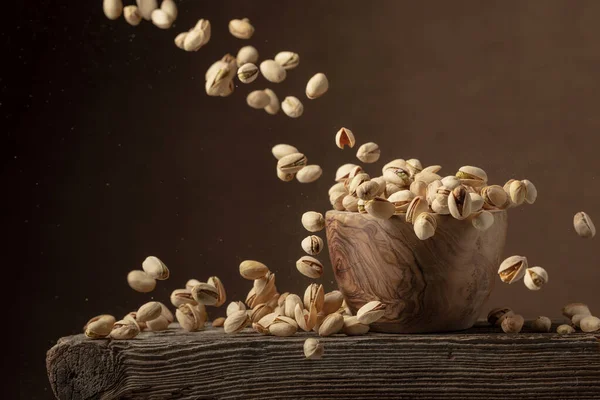 Flying Salted Pistachios Dried Nuts Wooden Bowl Copy Space — стоковое фото