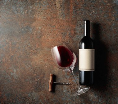 Eski kaba bir arka planda kırmızı şarap. Eski, boş etiketli bir şişe. Üst görünüm.