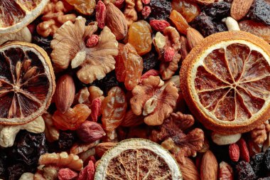 Kurutulmuş meyve ve fındık. Sunulan kuru üzüm, ceviz, badem, goji üzümü, kaju, portakal ve limon dilimleri. Üst görünüm.