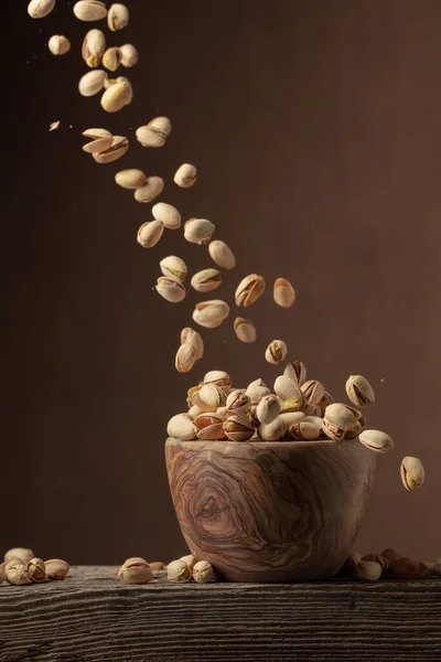 Flying Salted Pistachios Dried Nuts Wooden Bowl Copy Space — стоковое фото