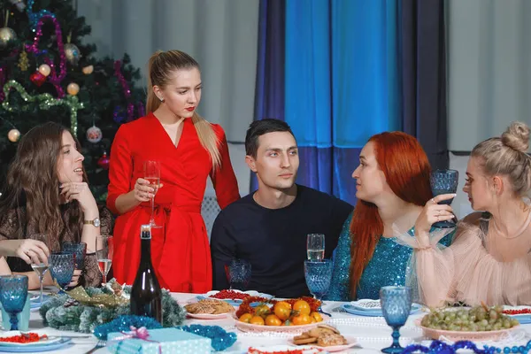 圣诞节和新年那天 金发女人在餐桌向朋友们敬礼 — 图库照片