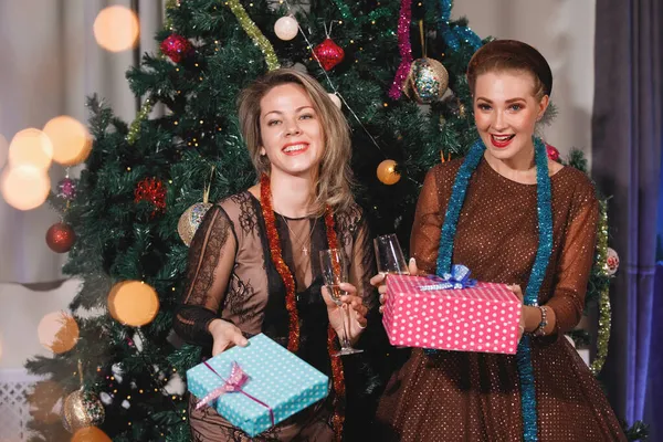 Twee Vriendinnen Geven Elkaar Cadeaudozen Bij Een Kerstboom — Stockfoto