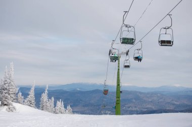 Karlı bir günde dağ evinde kulübeleri olan bir teleferik. Seçici odaklanma, bulanık arkaplan. 14.11.2020, Sheregesh, Rusya