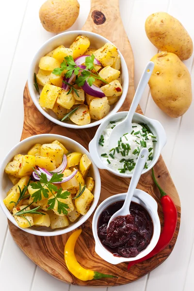Pieczone ziemniaki z sosem i kwaśną śmietaną — Zdjęcie stockowe