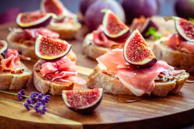 Ciabatta, proscuitto ve iştah açıcı olarak taze incirli küçük sandviçler.