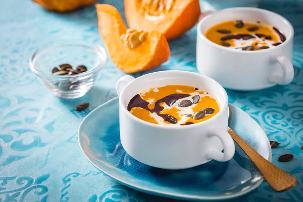 Hausgemachte Kürbissuppe Mit Kokosmilch Kürbisöl Und Samen Auf Blauem Hintergrund — Stockfoto