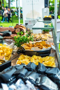 Yemek kamyonunda parmak yiyeceği çeşitleri. Patates cipsli sokak yemeği, sebze köftesi ve etli sandviç.