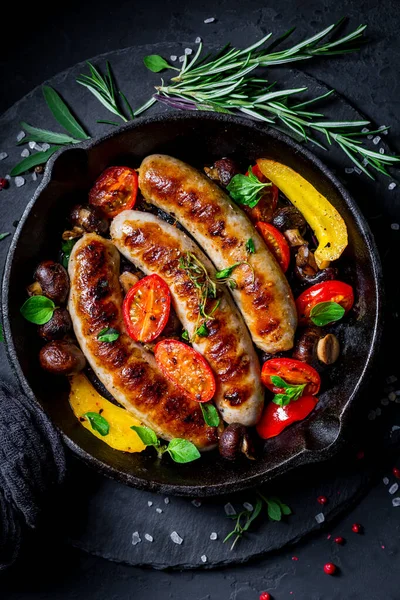 Embutidos Parrilla Verduras Con Hierbas Sartén Hierro Sobre Fondo Negro —  Fotos de Stock